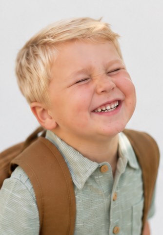 Boy scrunching his face in a big laugh